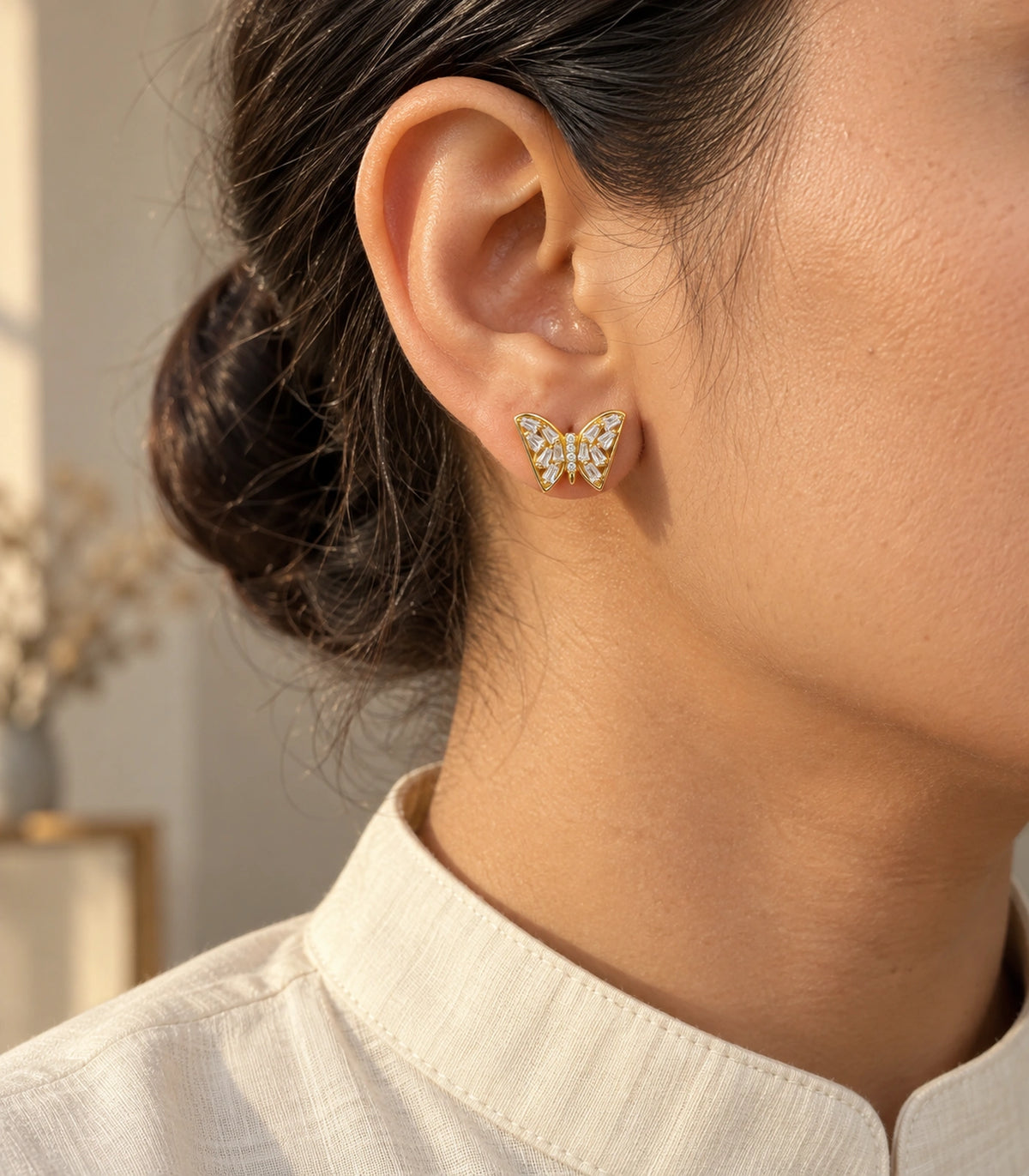 JIMIKI Gold Tone Clear Baguette Butterfly Stud Earring Pair in Gold tone, editorial model view