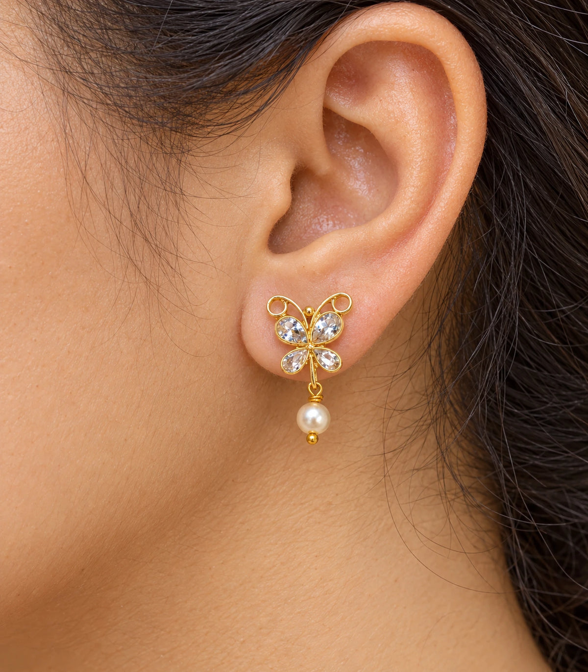 JIMIKI Clear Crystal butterfly pearl drop earrings, worn detail of the design #color_clear-crystal