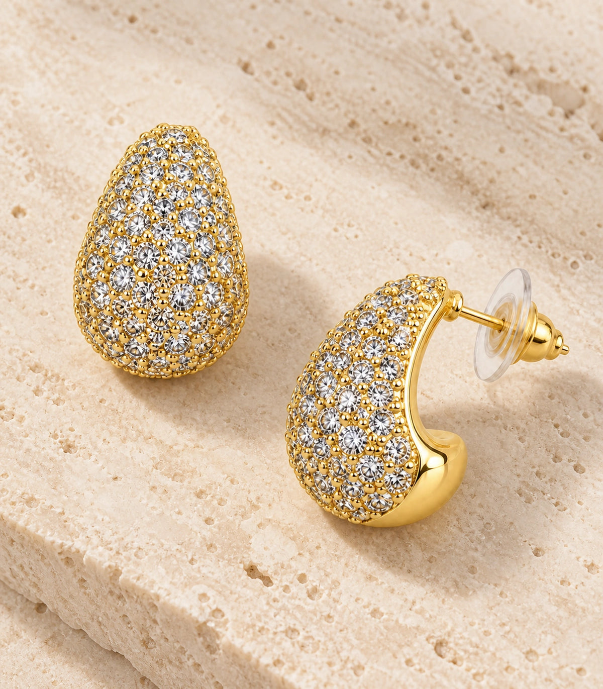 JIMIKI Gold Tone Clear Pave Teardrop Stud Earring Pair in Gold-tone, editorial flat lay