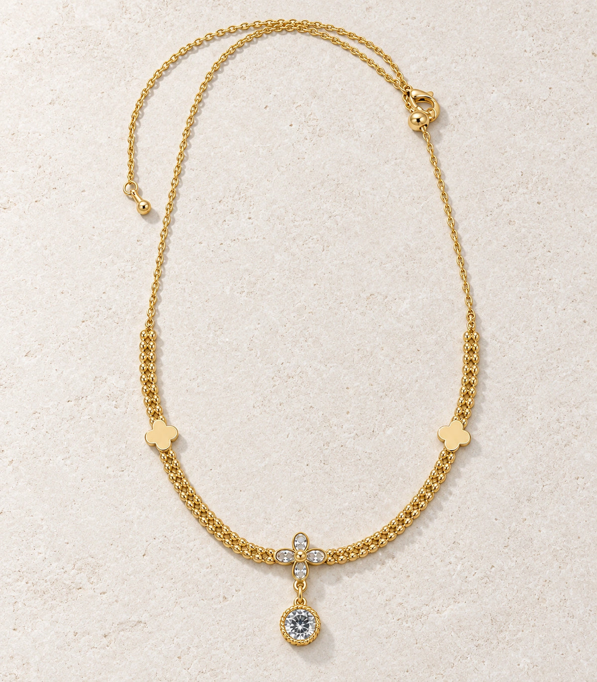 JIMIKI Clover Crystal Flower Drop Necklace in Gold Tone - editorial flatlay #color_gold-tone