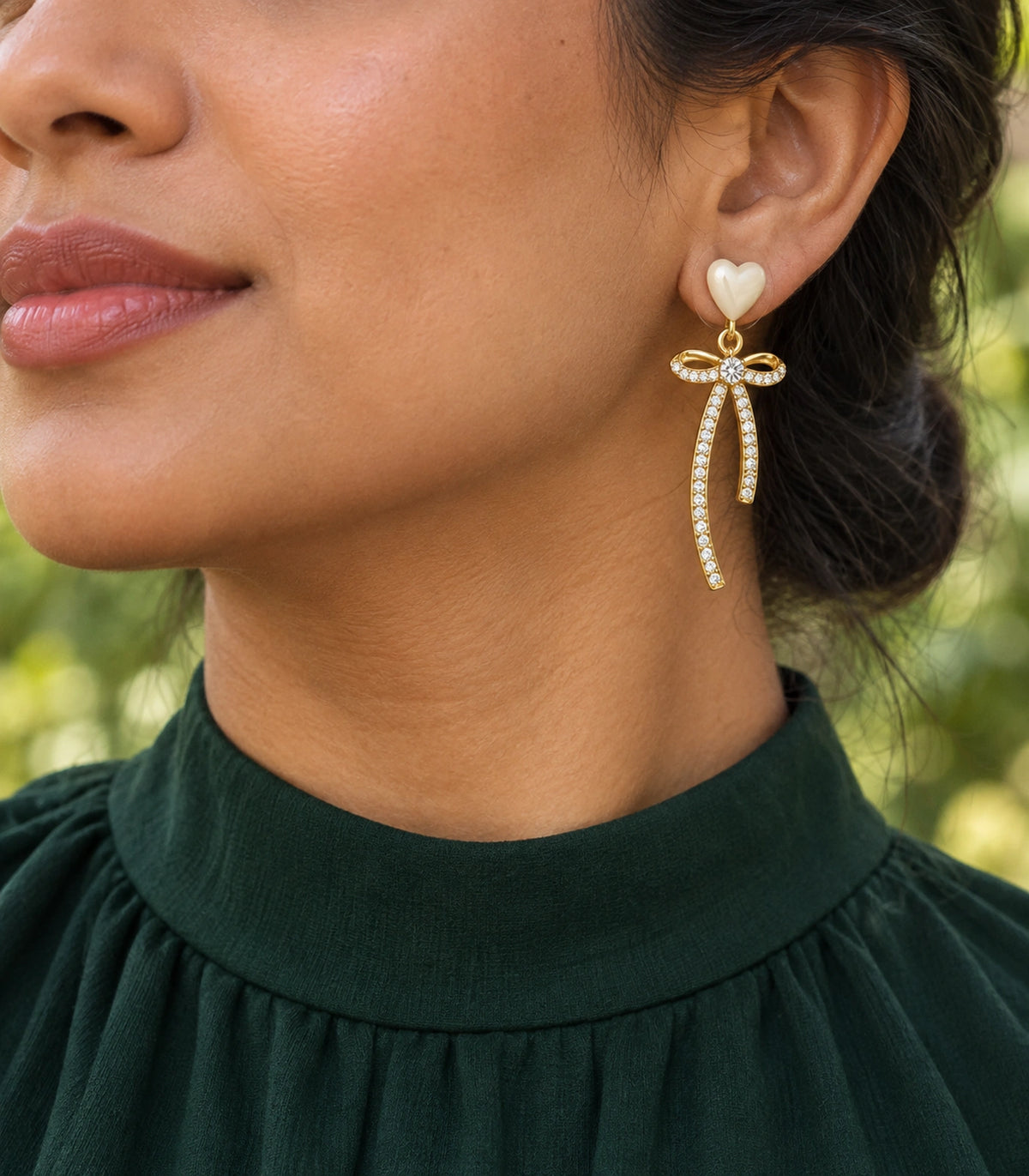 JIMIKI Heart Crystal Ribbon Bow Drop Earring Pair in Gold-tone / Cream, editorial model view #color_gold-tone / cream