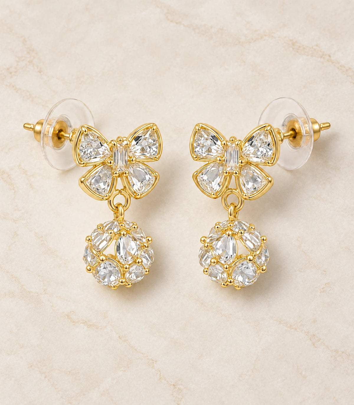 JIMIKI Gold-Tone Crystal Butterfly Ball Drop Earrings — pair in a styled flat lay #color_gold-tone / clear