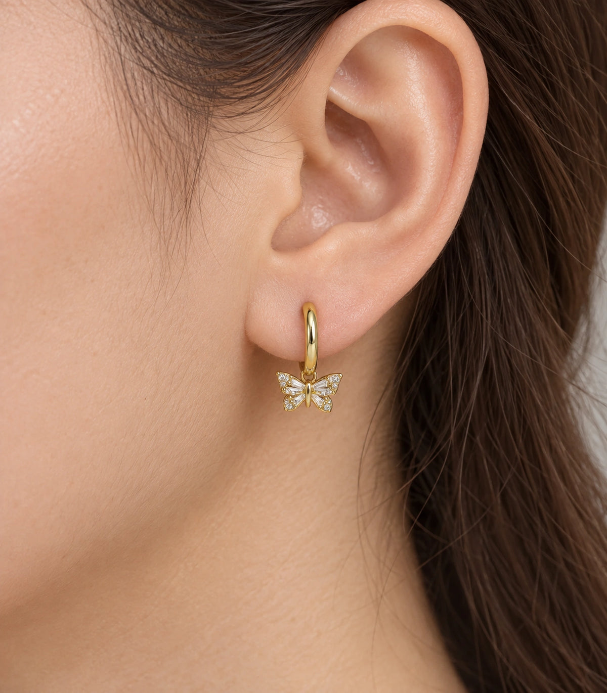 JIMIKI Crystal Butterfly Huggie Earrings in Gold / Clear, close-up detail #color_gold / clear