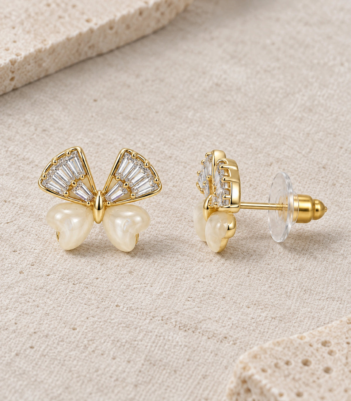 JIMIKI Crystal Wing Butterfly Stud Earring Pair in Gold Tone, editorial flat lay #color_gold tone