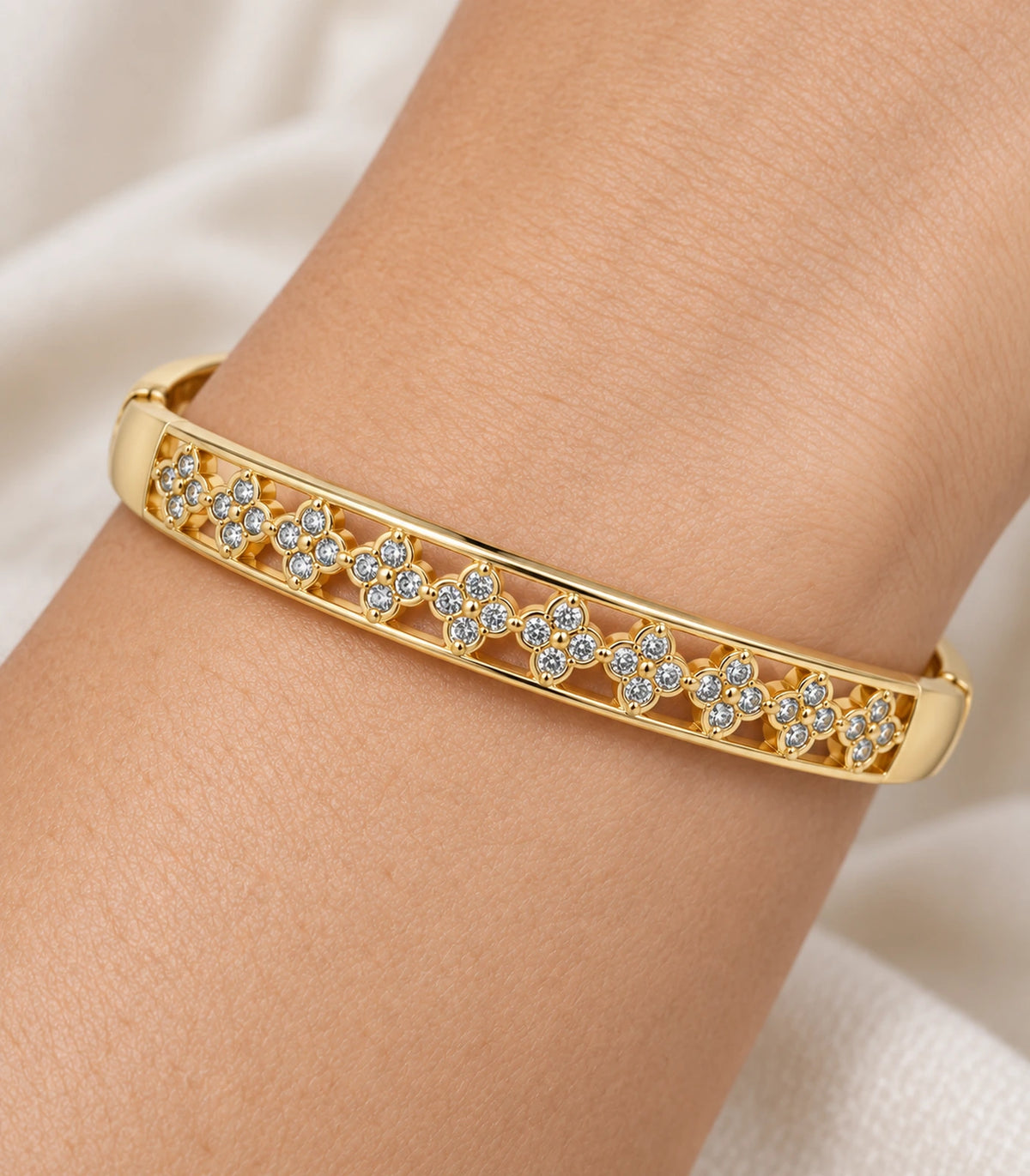 JIMIKI Gold-Tone Crystal Floral Lattice Bangle — close-up of the bangle worn on the wrist #color_gold-tone / clear