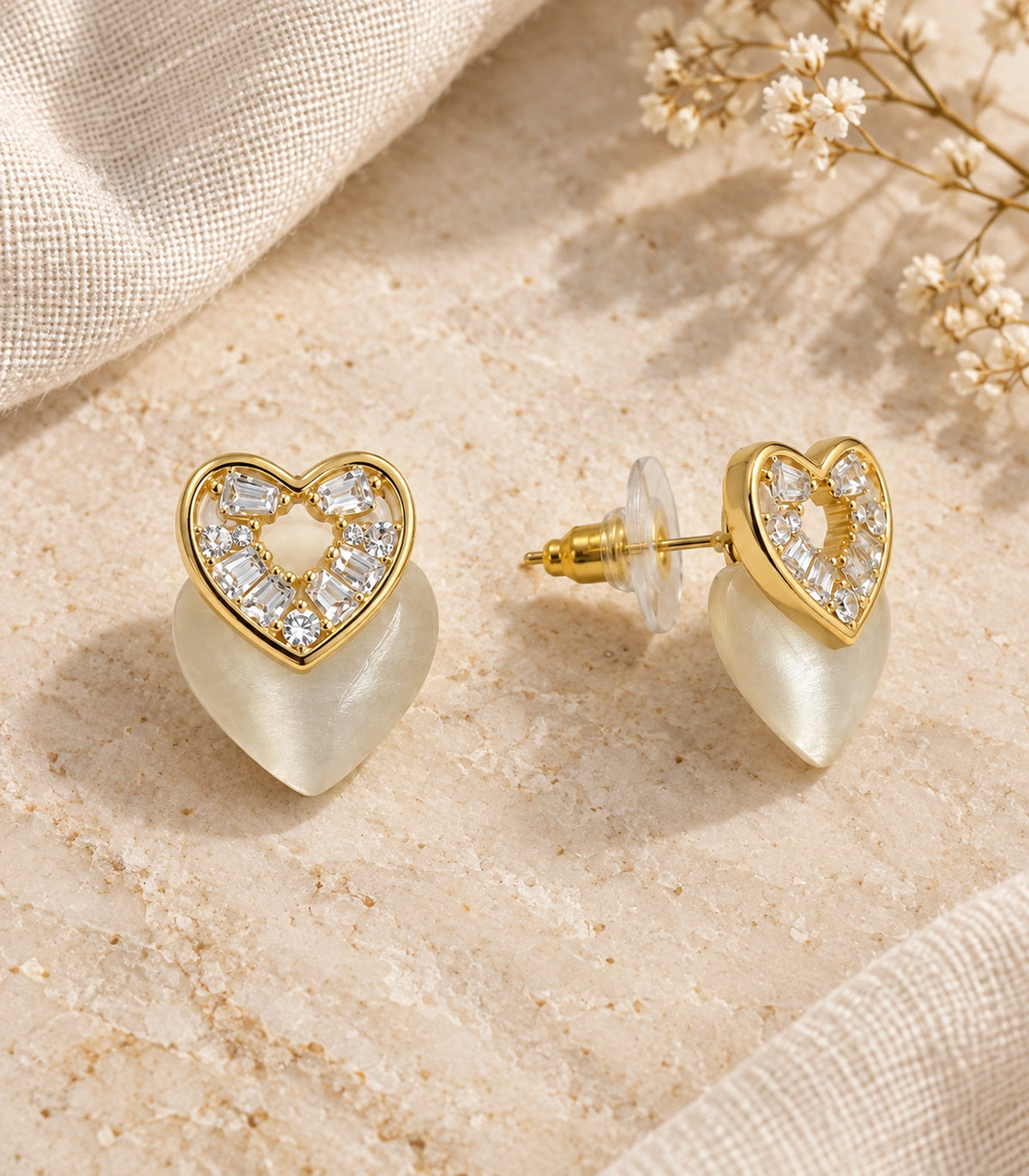JIMIKI Gold-Tone Crystal Heart Stud Earring Pair in Gold Tone, editorial flat lay