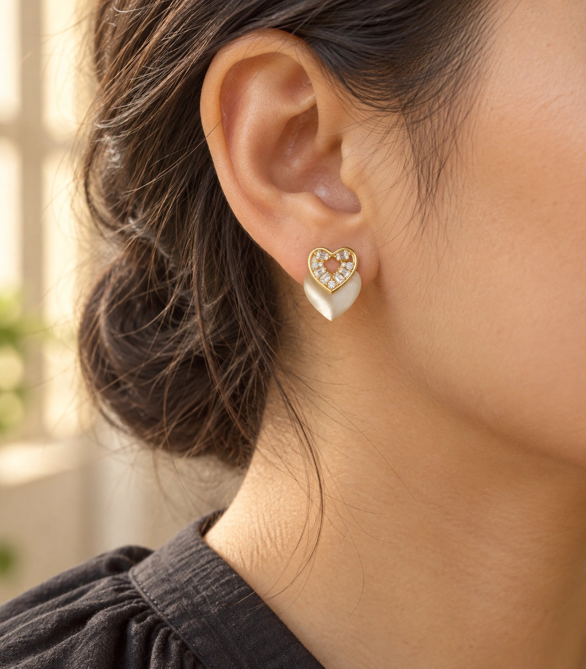 JIMIKI Gold-Tone Crystal Heart Stud Earring Pair in Gold Tone, editorial model view