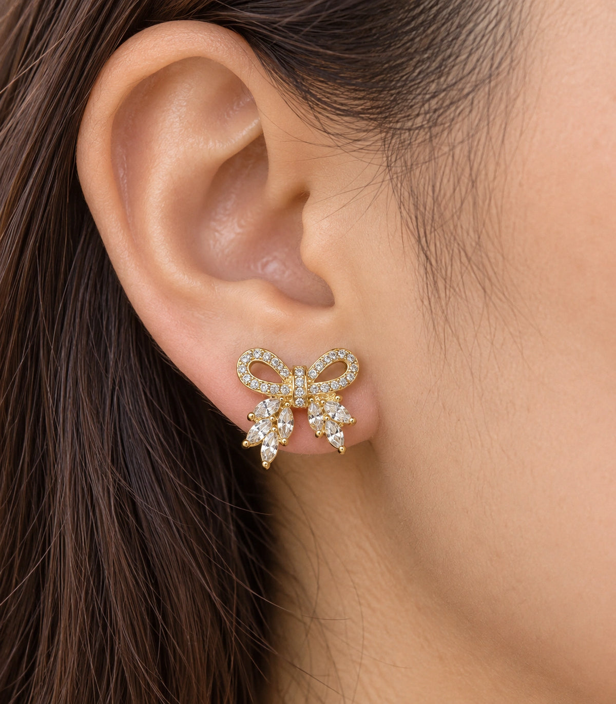 JIMIKI Gold-Tone Crystal Loop Bow Stud Earrings in Gold / Clear, close-up detail