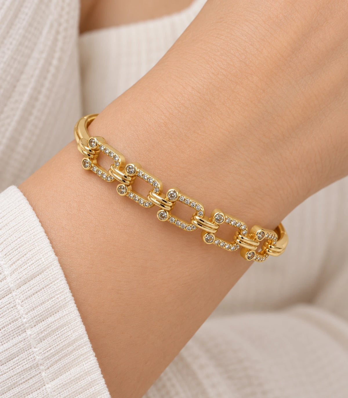 JIMIKI Gold-Tone Crystal Open Link Bangle — close-up of the bangle worn on the wrist #color_gold-tone / clear