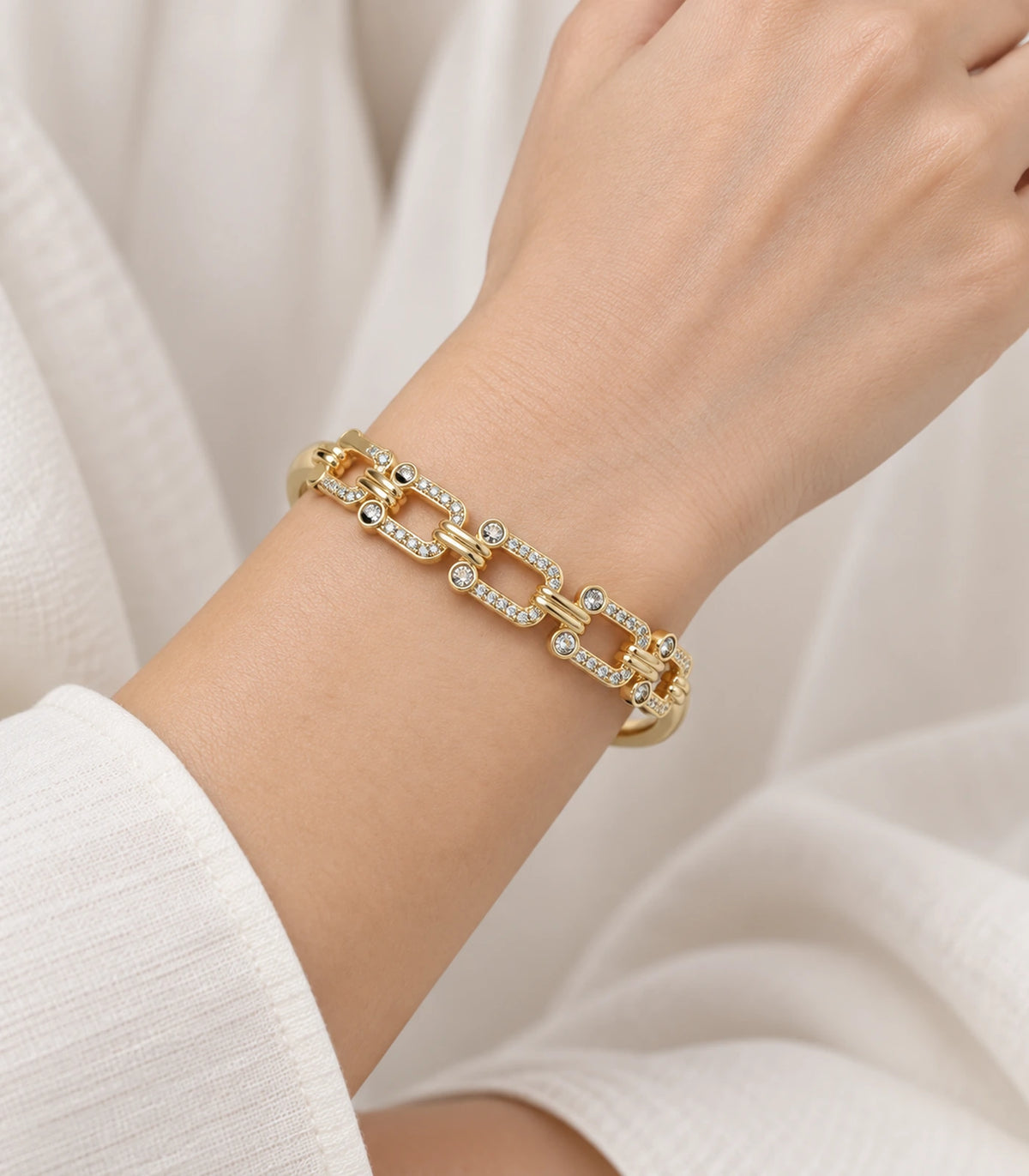 JIMIKI Gold-Tone Crystal Open Link Bangle — worn on the wrist #color_gold-tone / clear
