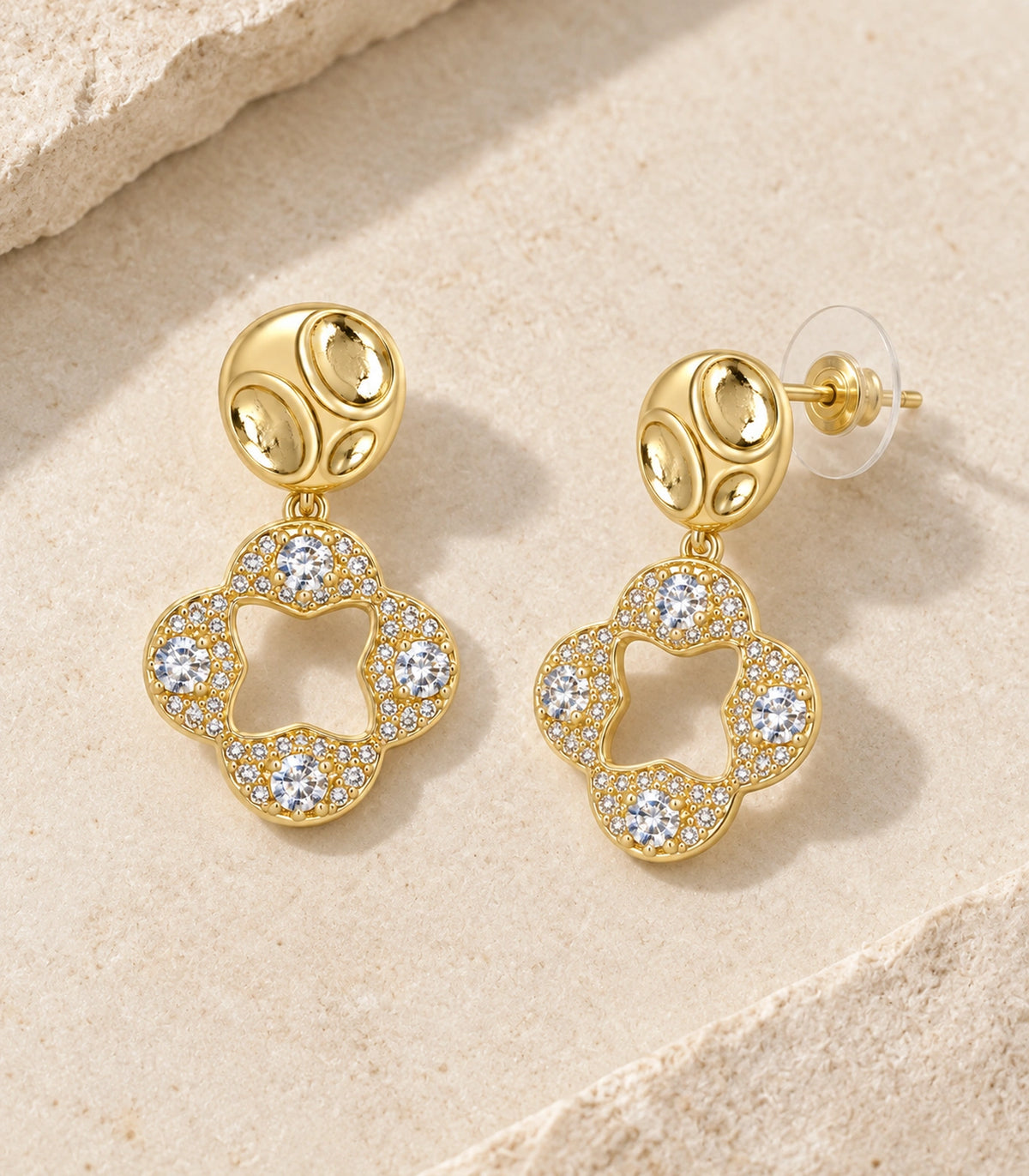 JIMIKI Gold-Tone Crystal Open Quatrefoil Organic Pebble Drop Earrings in Gold / Clear, editorial flat lay