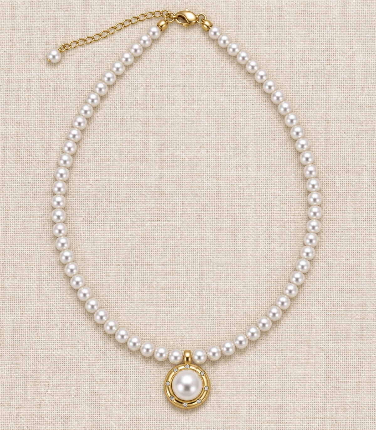 JIMIKI Gold Tone Crystal Rim Pearl Pendant Necklace in Gold / White, editorial flat lay