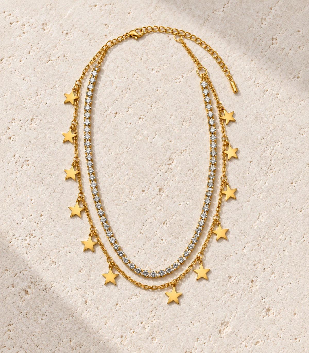 JIMIKI Gold-Tone Crystal Star Layered Necklace in Gold Tone - editorial flatlay #color_gold-tone