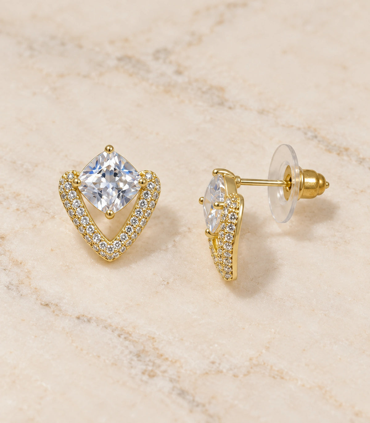 JIMIKI Gold Tone Cushion Crystal V Frame Stud Earring Pair in Gold-tone, editorial flat lay