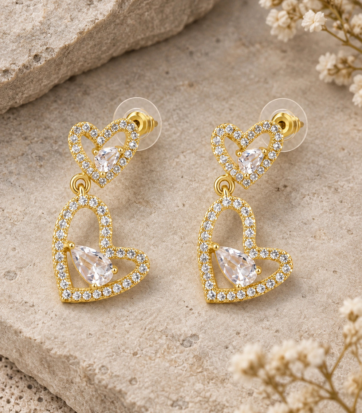 JIMIKI Double Heart Pear Crystal Drop Earrings in Gold Tone, editorial flat lay #color_gold tone