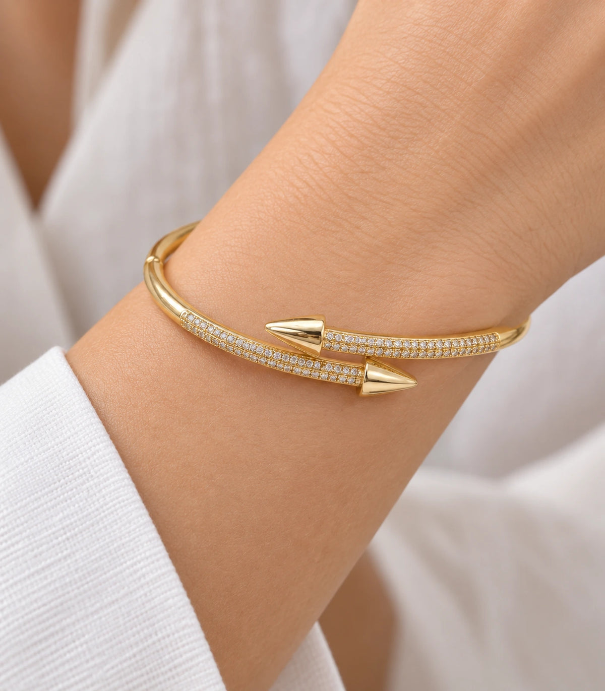 JIMIKI Gold-Tone Double Row Pavé Spear Wrap Bangle — close-up of the bangle worn on the wrist #color_gold-tone / clear