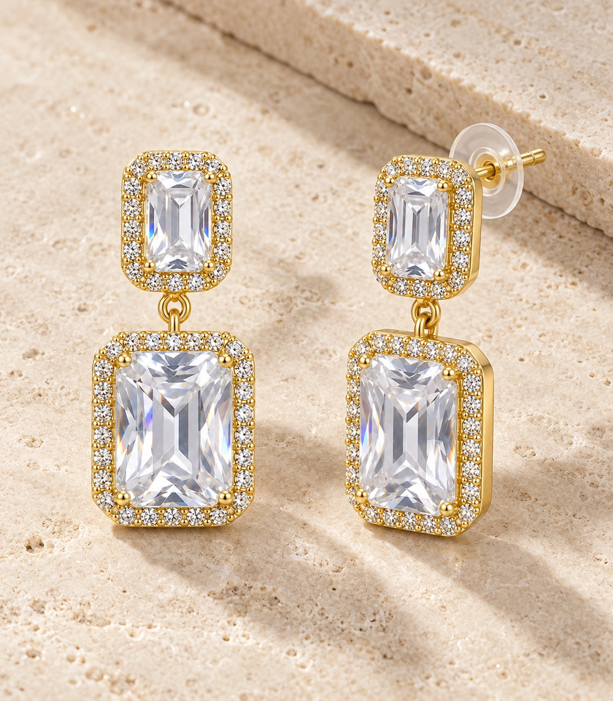JIMIKI Gold-Tone Emerald-Cut Crystal Double Rectangle Drop Stud Earrings in Gold / Clear, editorial flat lay