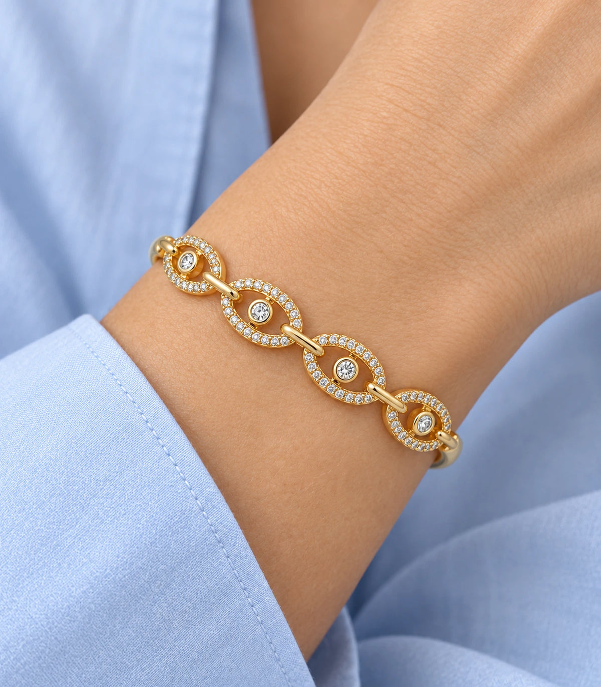 JIMIKI Gold-Tone Four Oval Halo Crystal Bangle — close-up of the bangle worn on the wrist #color_gold-tone / clear