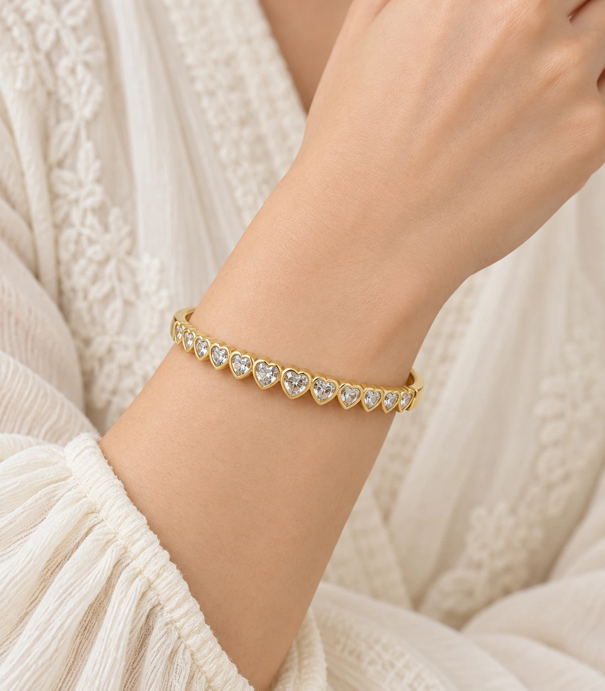 JIMIKI Gold-Tone Graduated Heart Crystal Bangle — worn on the wrist #color_gold-tone / clear