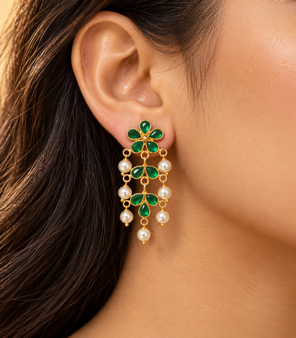 JIMIKI green floral pearl-style chandelier earrings, worn in warm editorial light #color_green