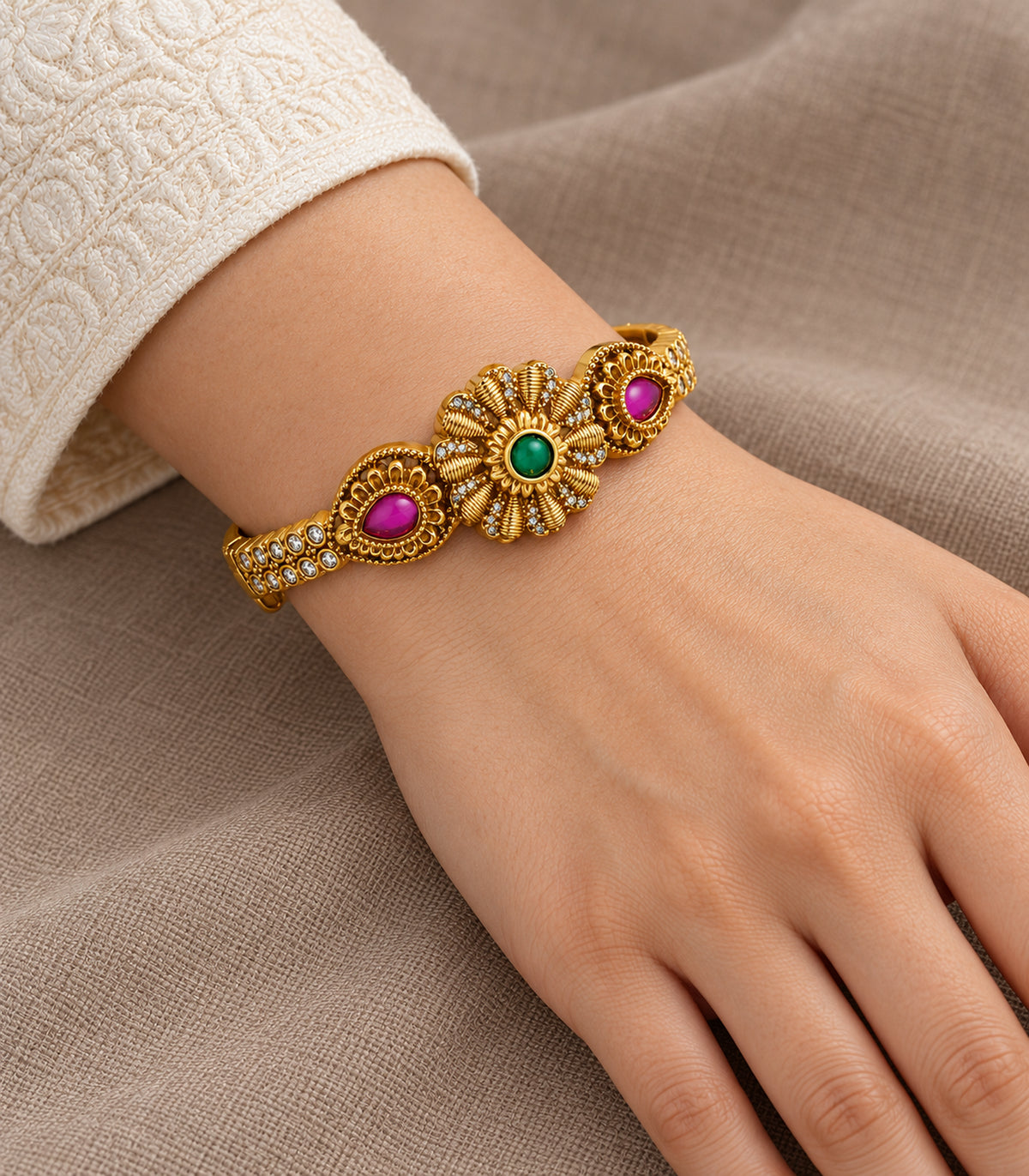 Gold-tone green flower and magenta teardrop single bangle — closeup view