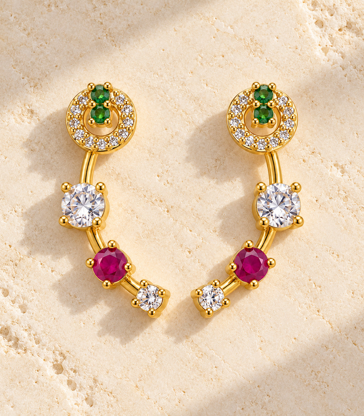 Gold-tone green and magenta curved crystal earrings - editorial flatlay view