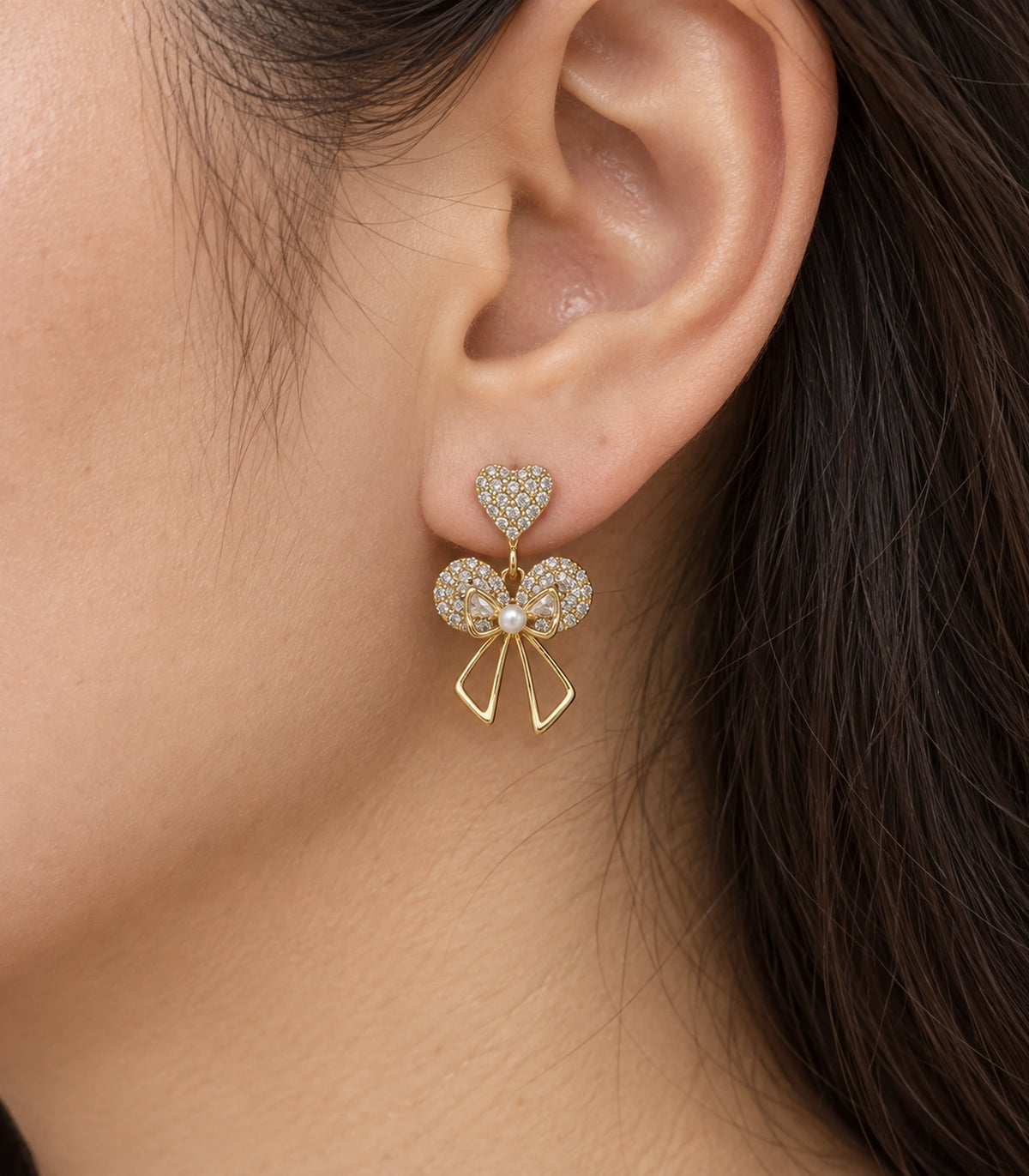 JIMIKI Gold-Tone Heart Bow Pearl Drop Earrings in Gold / Clear / White, close-up detail