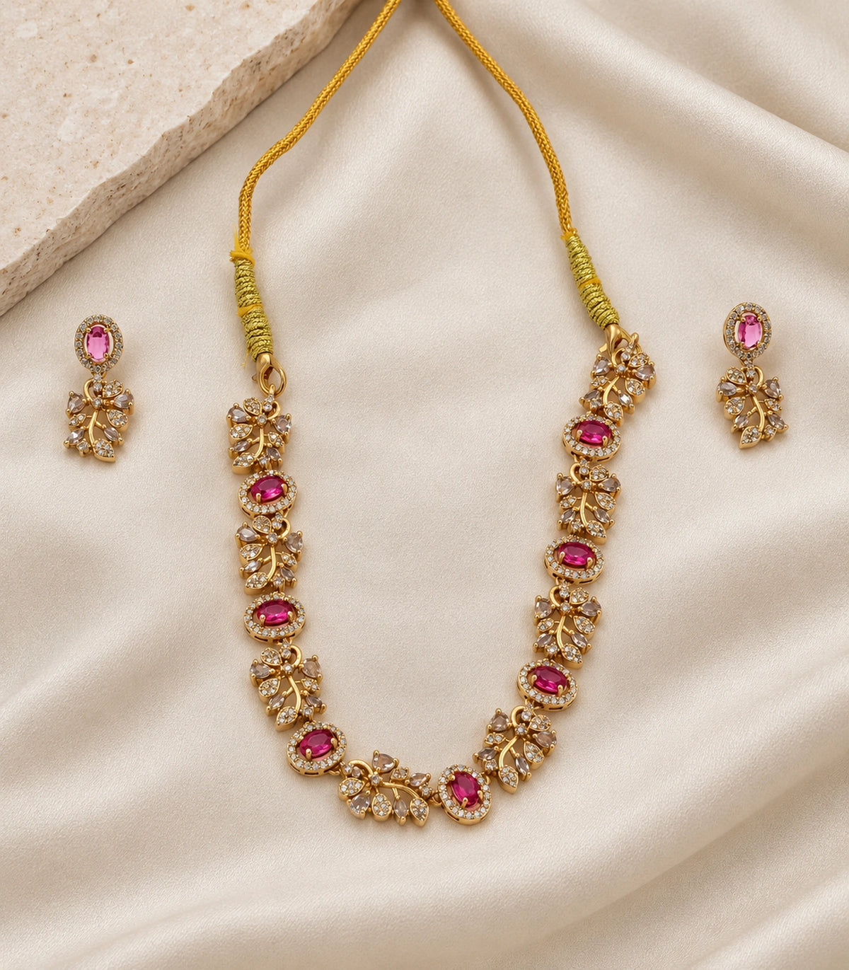 Magenta Crystal Floral-Link Necklace Set and matching earrings arranged on ivory fabric #Color_Magenta