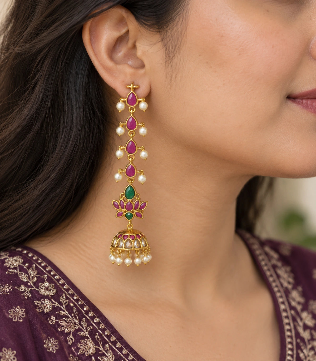 Gold-tone magenta and green lotus jhumka earring worn at the ear