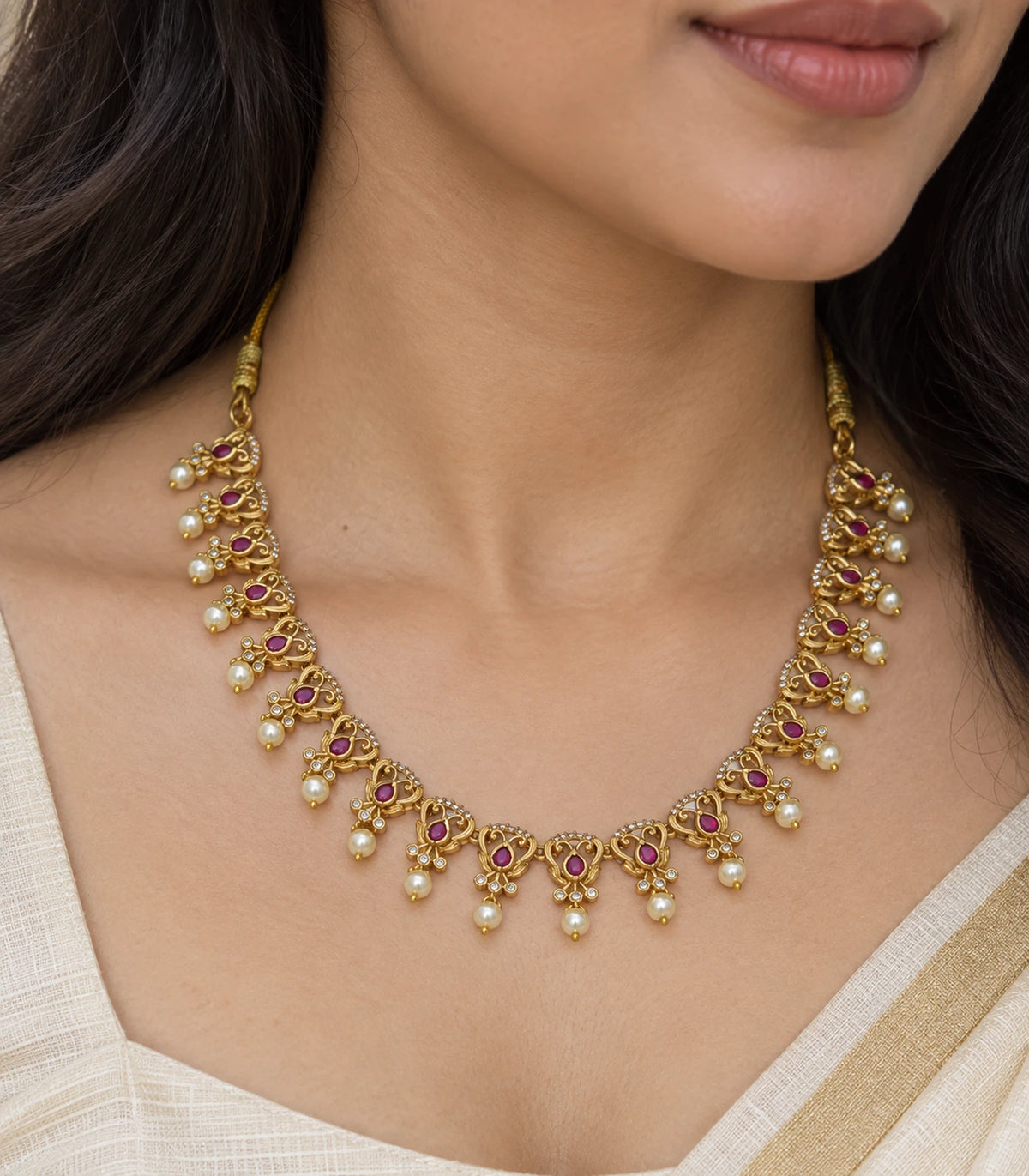 Close view of the magenta accents and pearl-style drops on the collar necklace