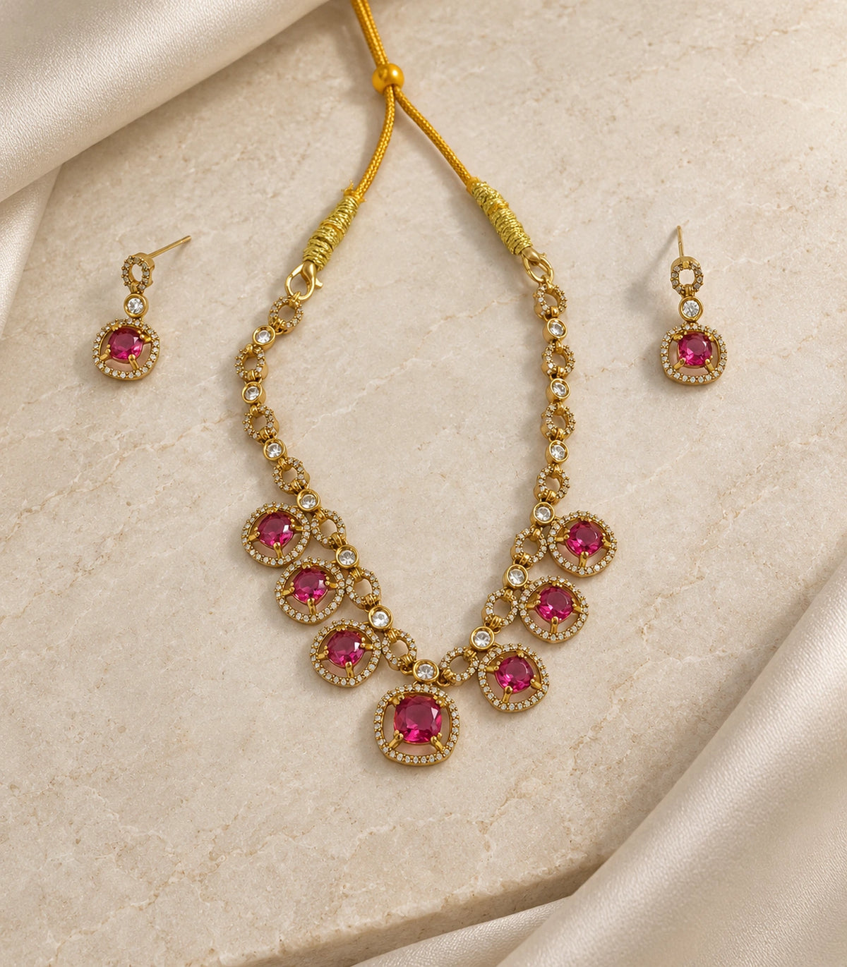 Round Crystal Teardrop Necklace Set in Magenta with gold-tone finish, editorial flat lay #Color_Magenta
