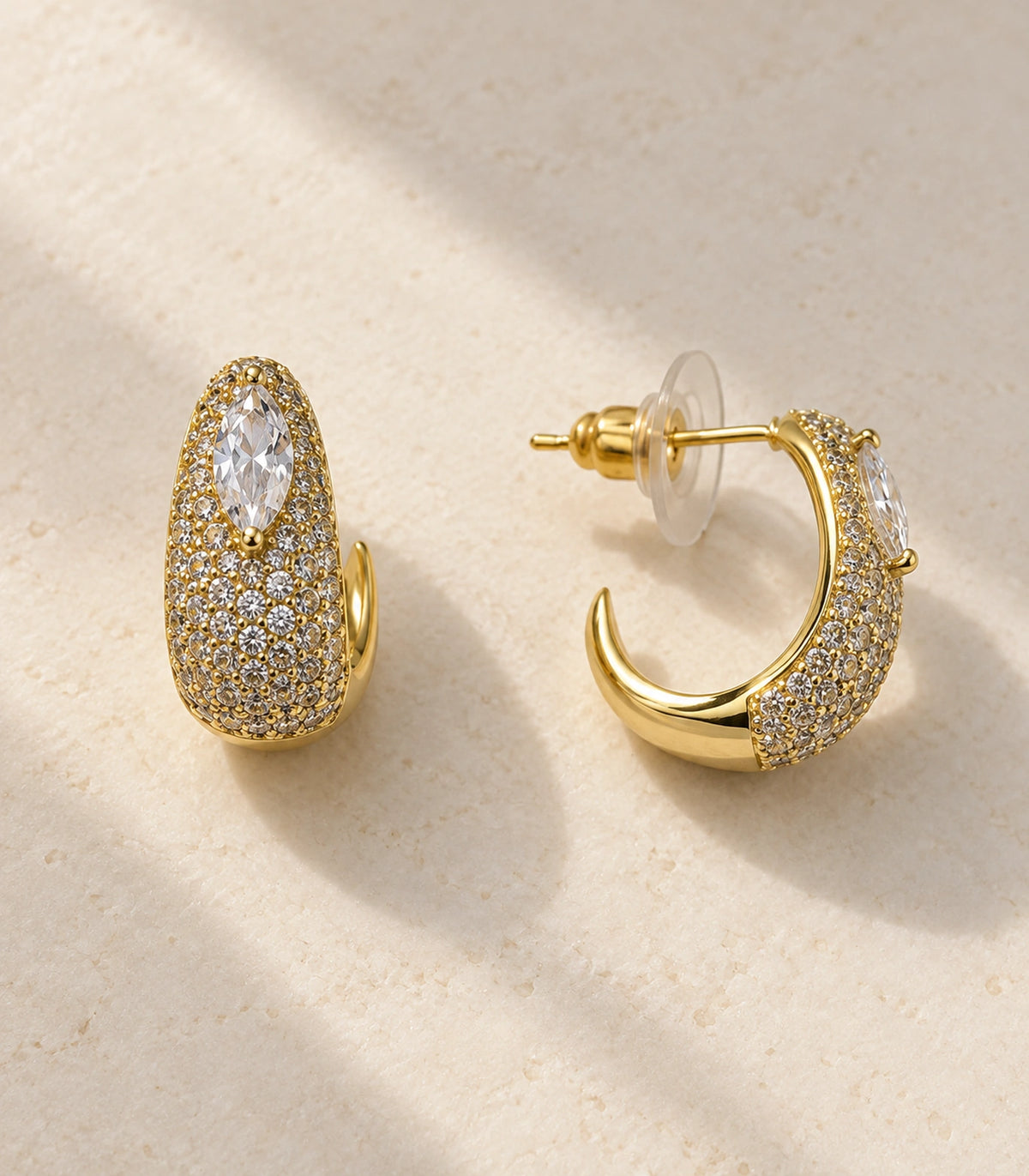 JIMIKI marquise pave open hoop earring pair in gold tone in an editorial flat lay #color_gold tone