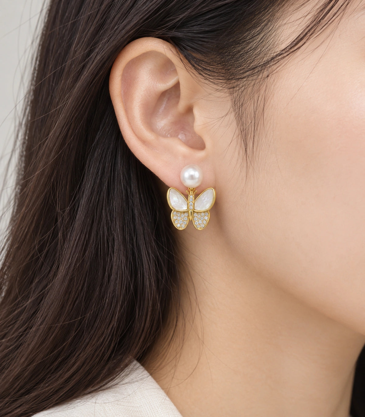 JIMIKI Gold-Tone Pearlescent Butterfly Pearl-Style Stud Earrings in Pearl White / Gold, model wearing view