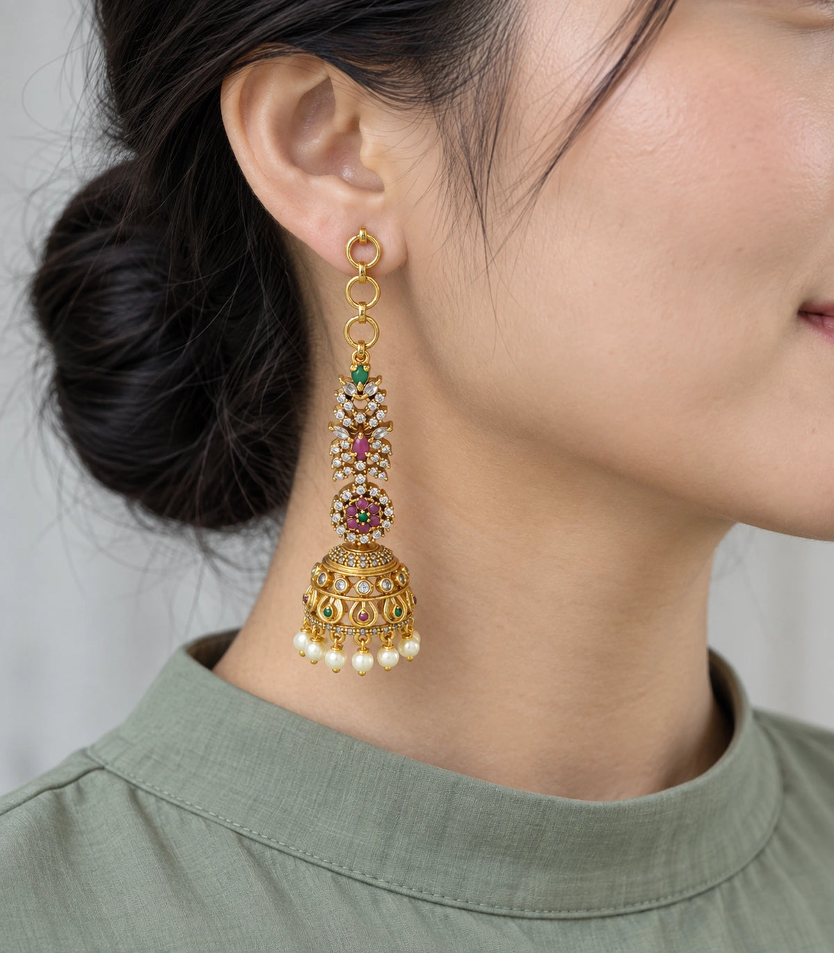 Gold-tone multicolor jhumka earring worn with circular links and pearl-style drops