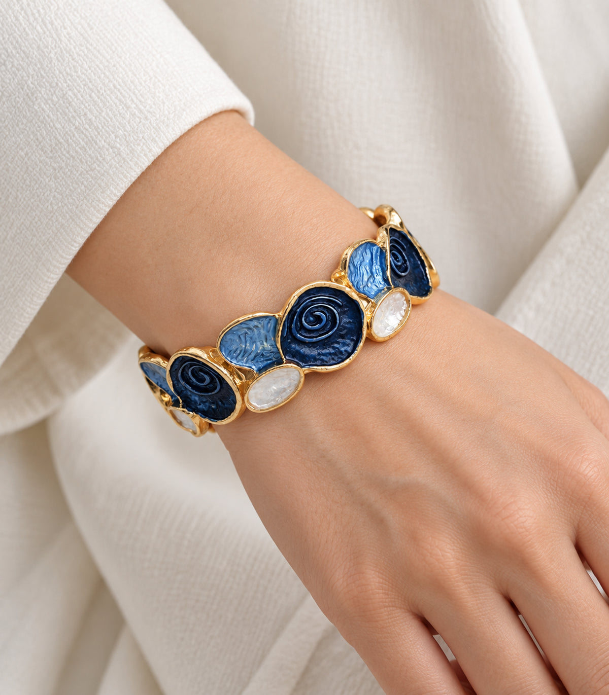 Gold-tone navy spiral and blue fan panel bracelet — closeup view
