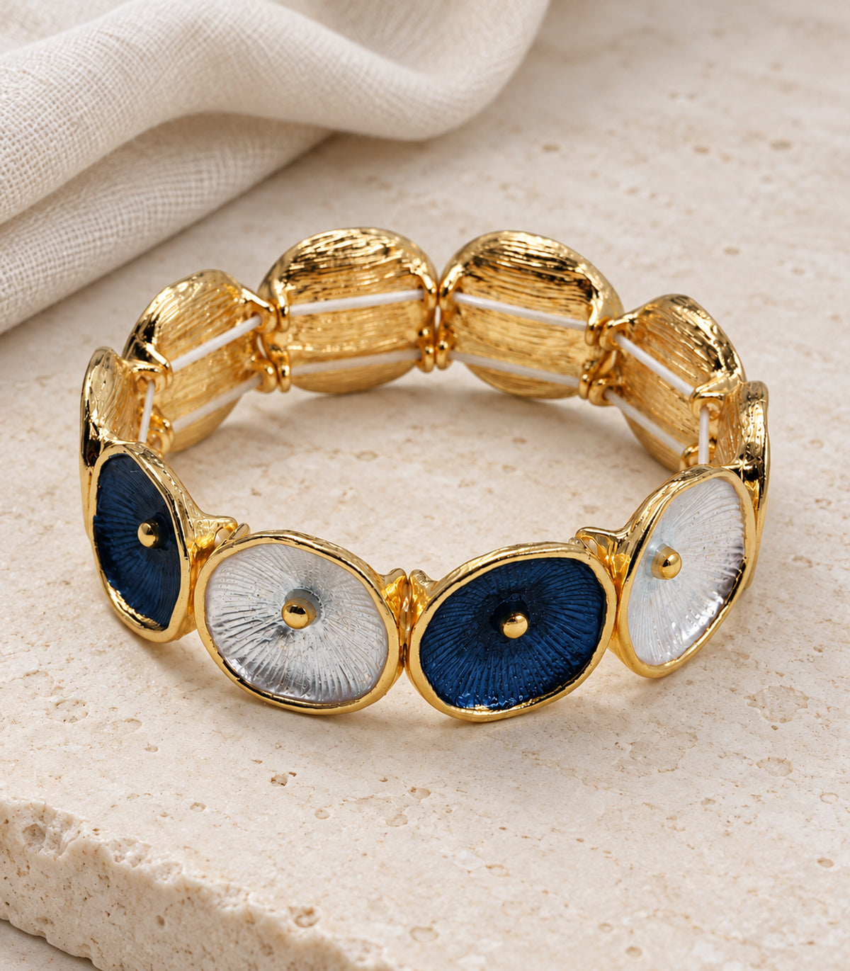 JIMIKI gold-tone navy and white oval disc bracelet — editorial flatlay