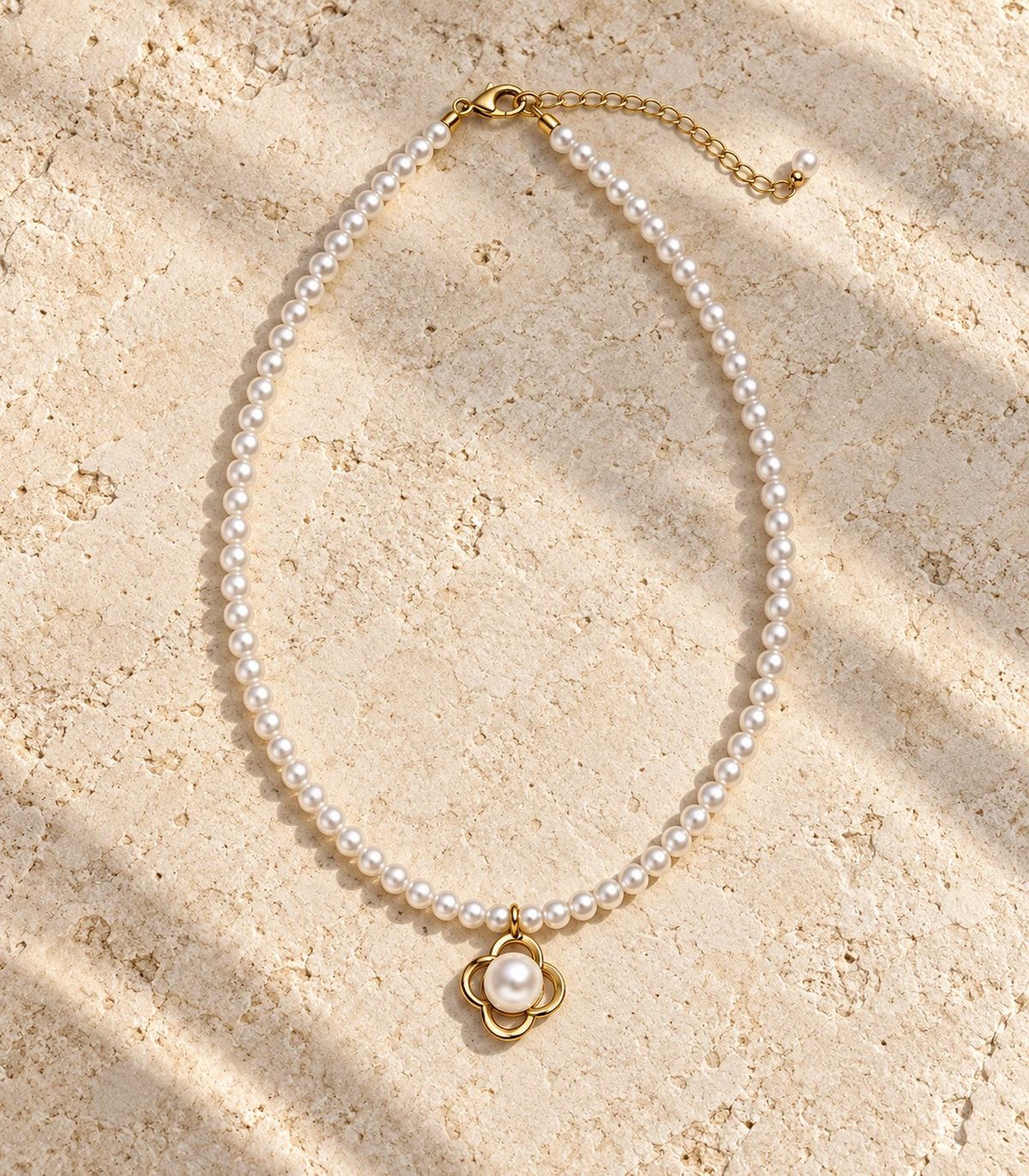 JIMIKI Gold Tone Open Clover Pearl Style Necklace in Gold tone / white, editorial flat lay
