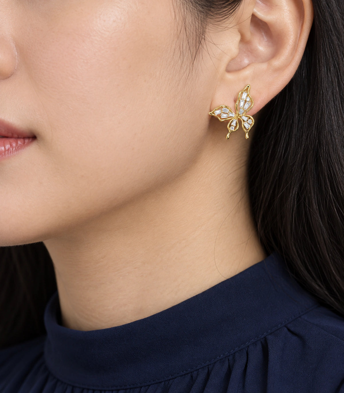 JIMIKI Openwork Baguette Crystal Butterfly Stud Earring Pair in Gold-tone, model wearing view #color_gold-tone