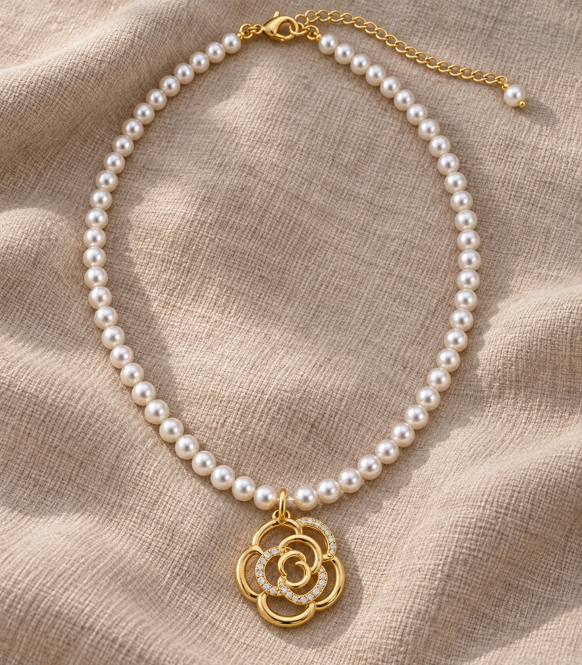 JIMIKI Gold Tone Openwork Rose Crystal Pearl Necklace in Gold / White, editorial flat lay