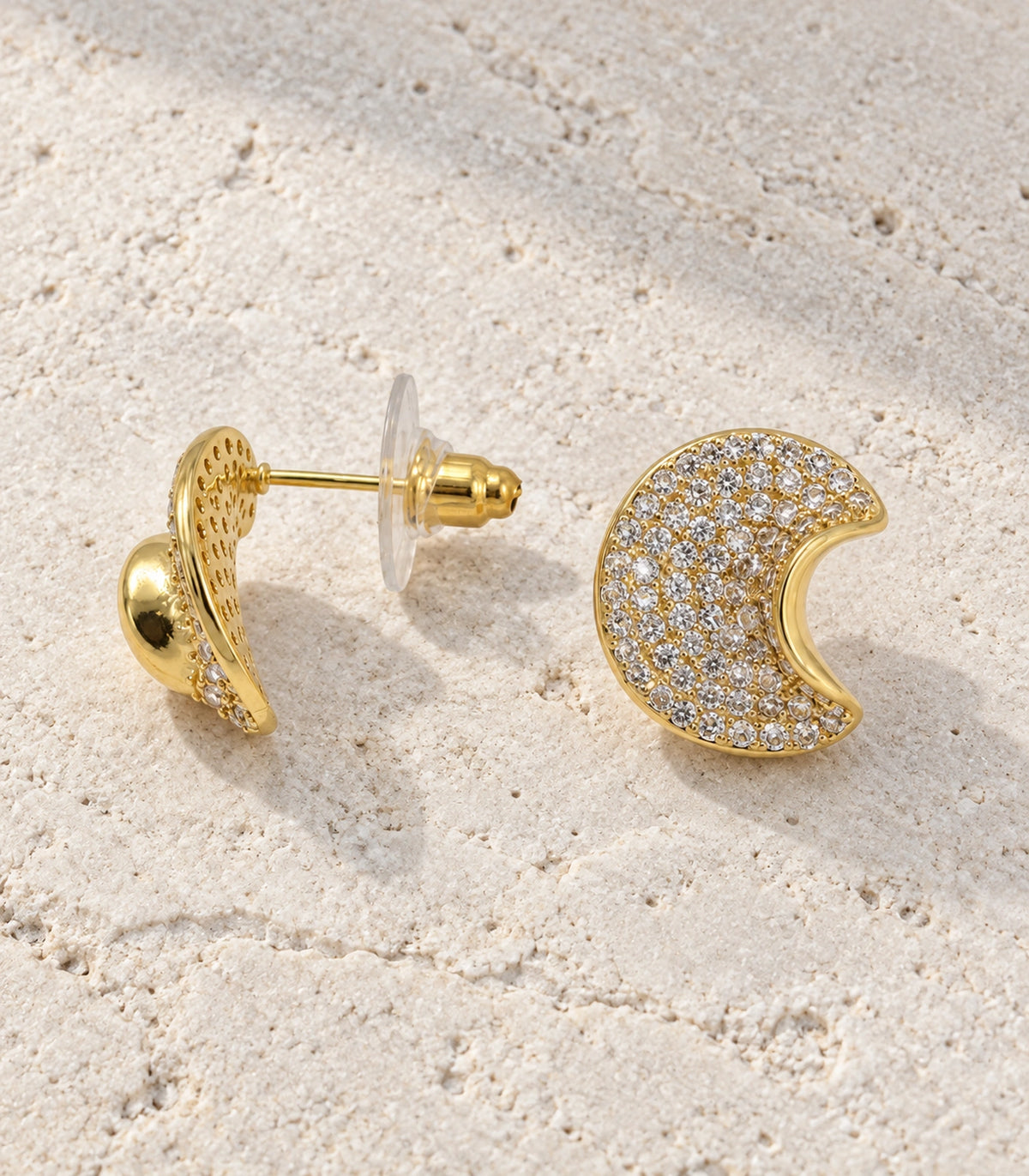 JIMIKI Pave Crescent Moon Stud Earring Pair in Gold-tone, editorial flat lay #color_gold-tone