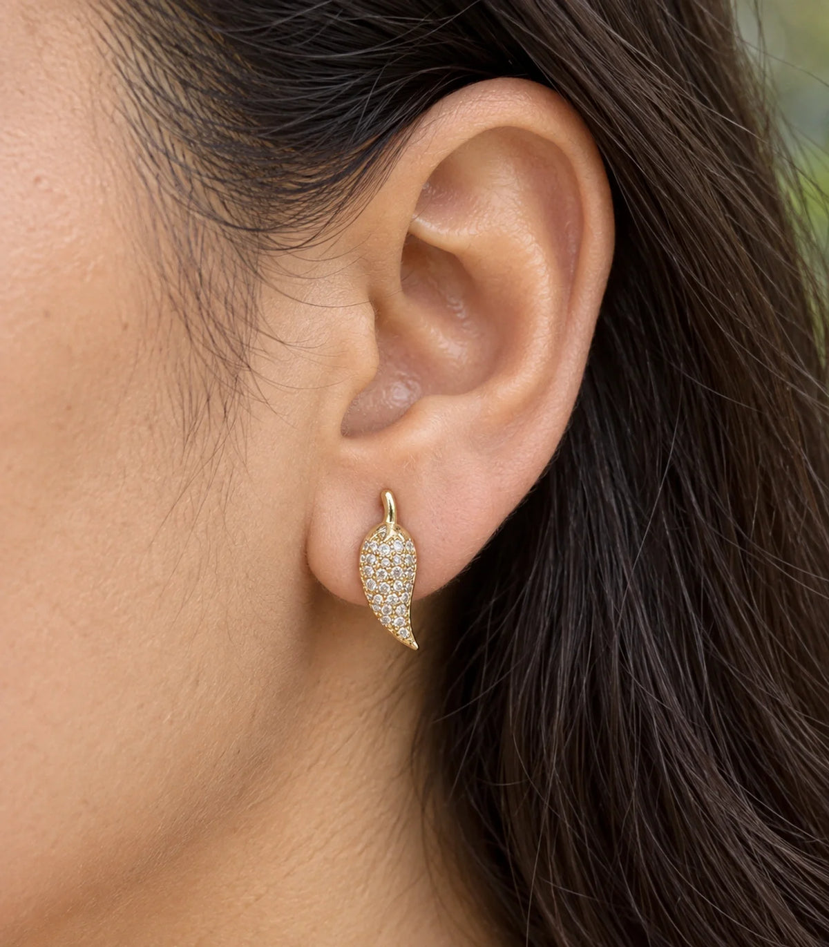 JIMIKI Gold Tone Pave Leaf Stud Earrings - worn close-up showing earring detail #color_gold-tone