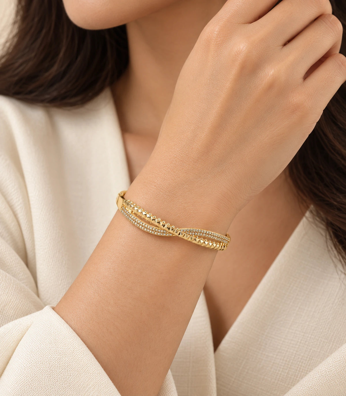 JIMIKI Gold-Tone Pavé Pyramid Crossover Bangle — worn on the wrist #color_gold-tone / clear