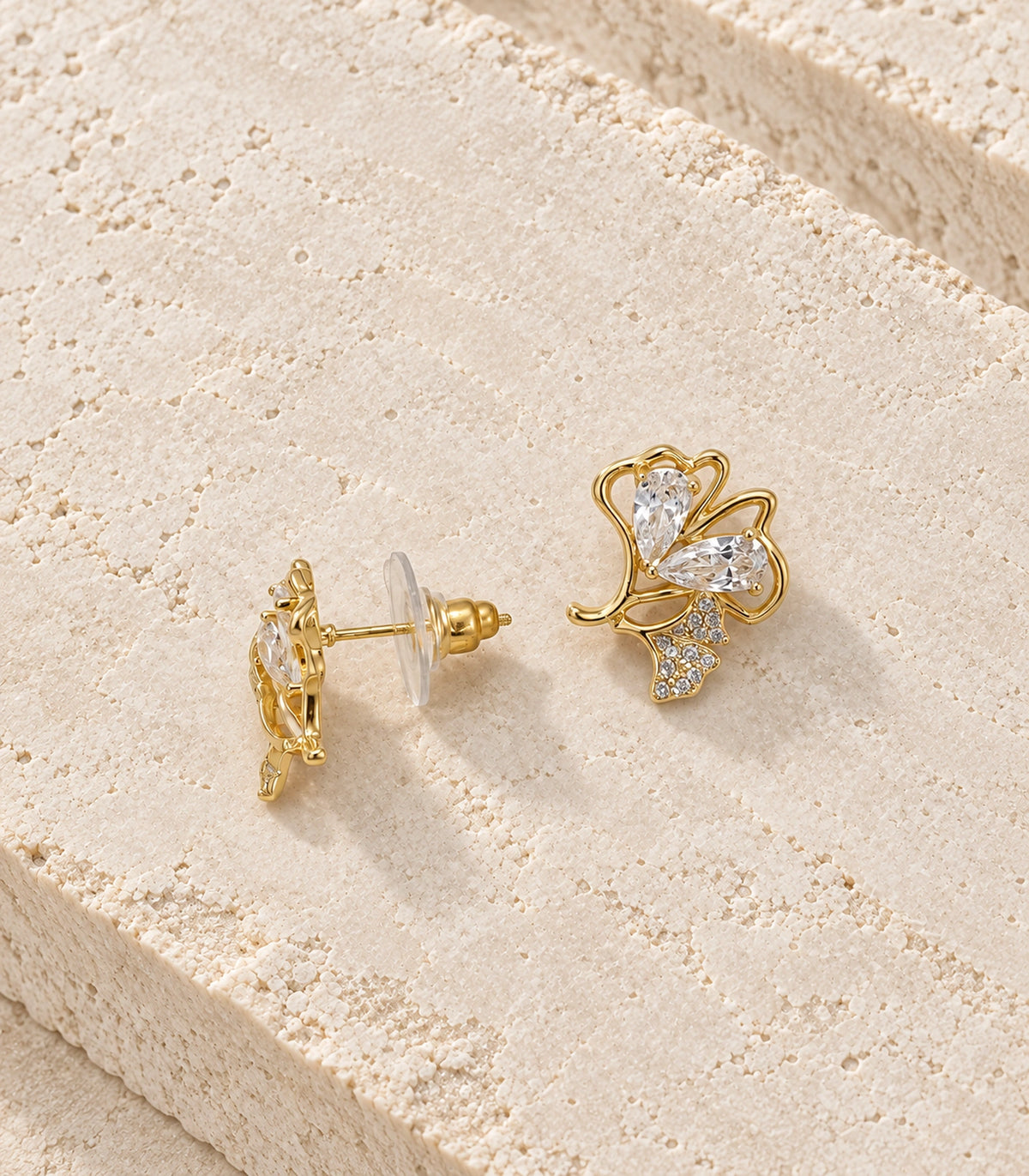 JIMIKI Pear Crystal Open Leaf Stud Earring Pair in Gold Tone, editorial flat lay #color_gold tone