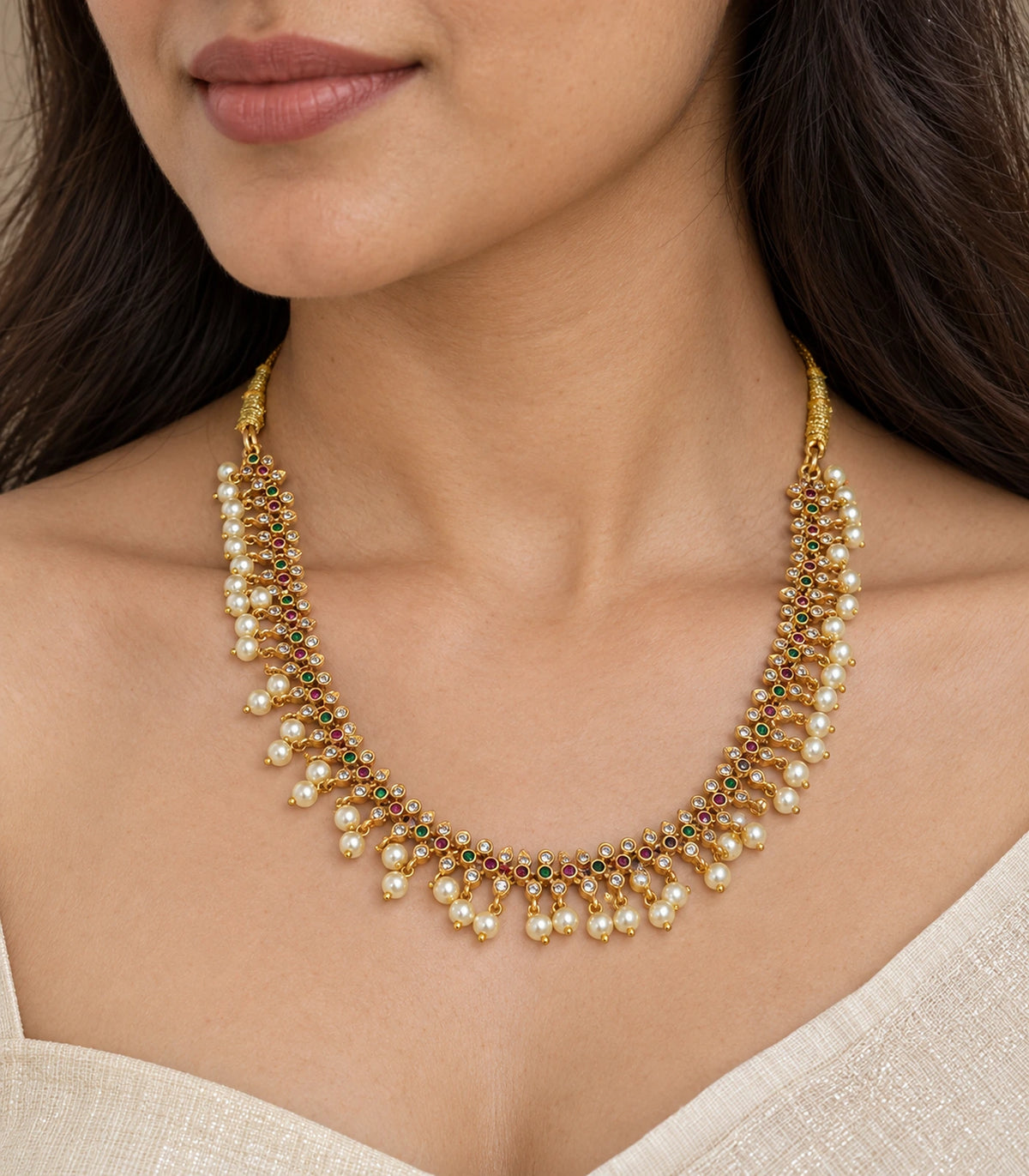 Close view of gold-tone pearl lattice collar necklace with coloured accents and pearl-style drops