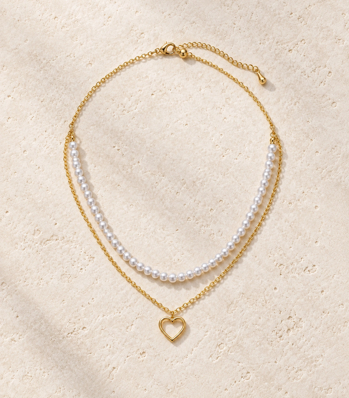 JIMIKI Gold-Tone Pearl Open-Heart Layered Necklace in Gold Tone - editorial flatlay #color_gold-tone