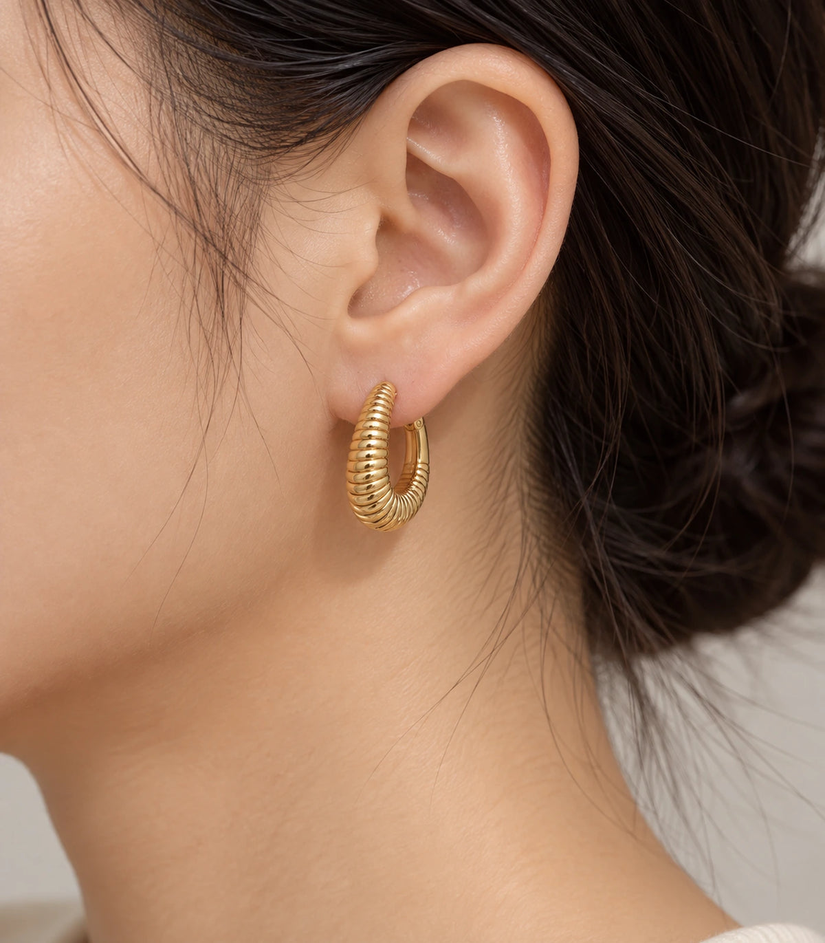 JIMIKI Ribbed Teardrop Hoop Earrings in Gold Tone - editorial model #color_gold-tone