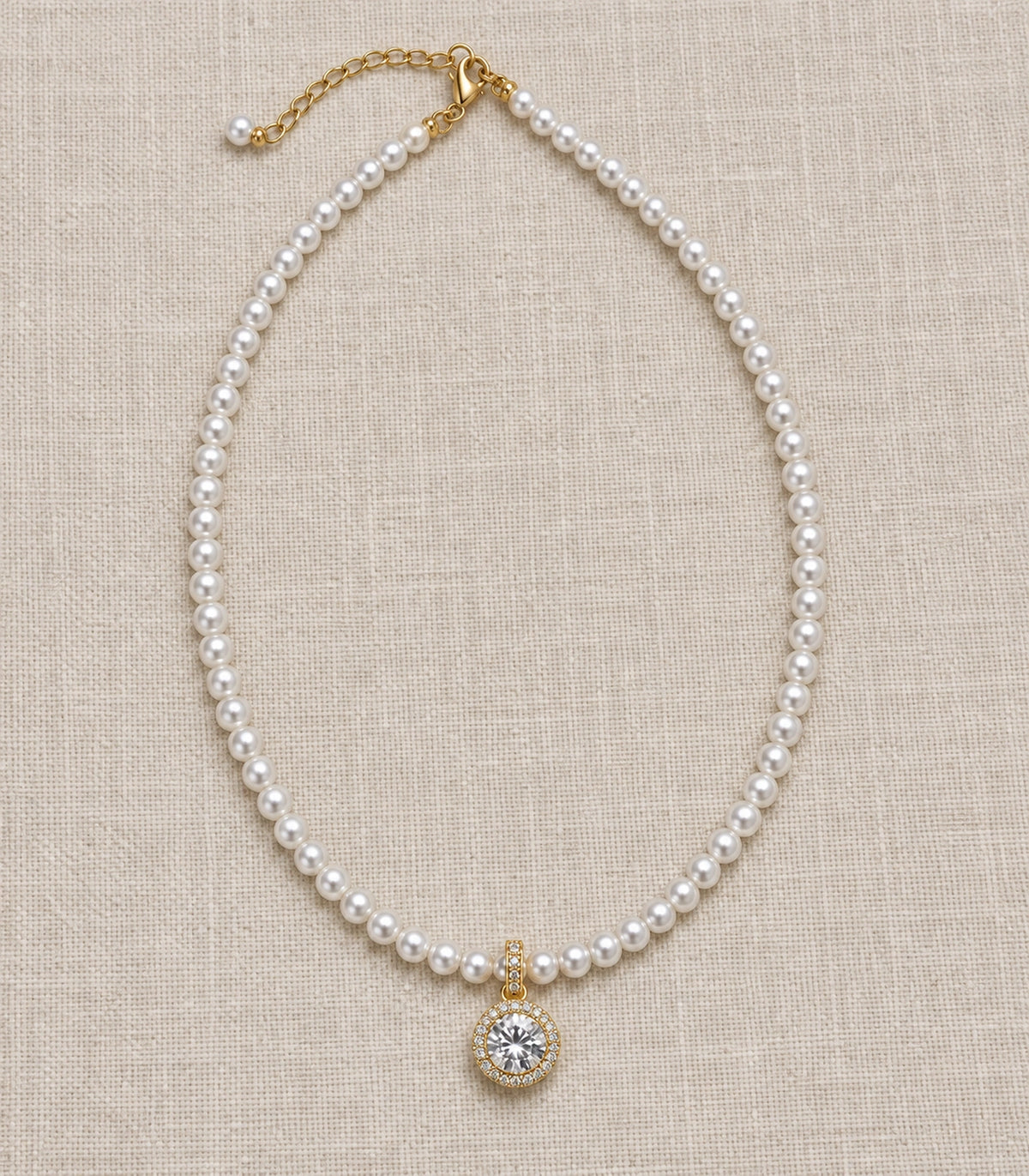 JIMIKI Gold Tone Round Halo Crystal Pearl Style Necklace in Gold tone / white, editorial flat lay