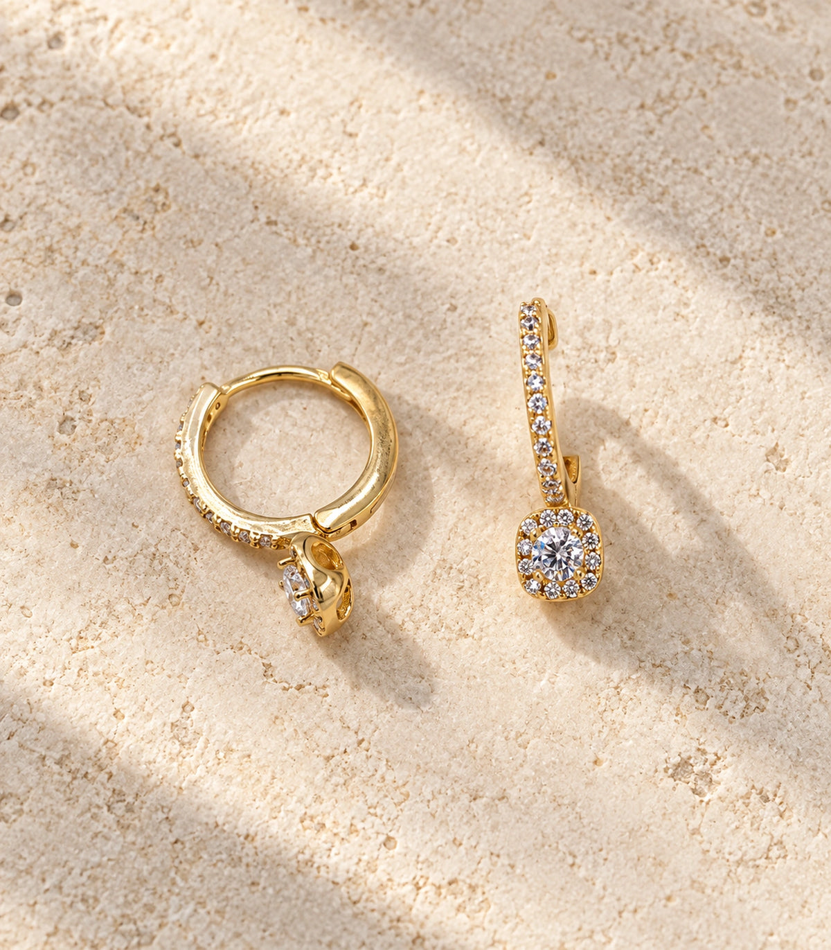 JIMIKI Gold-Tone Round Halo Solitaire Drop Huggie Earrings in Gold / Clear, editorial flat lay