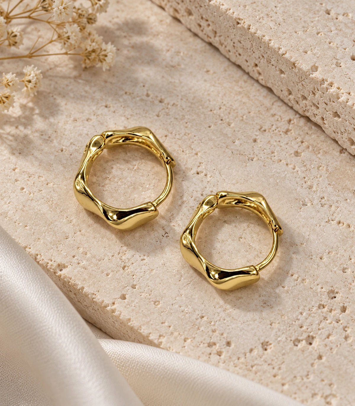 JIMIKI Gold Tone Sculpted Twist Hoop Earrings in Gold Tone - editorial flatlay #color_gold-tone