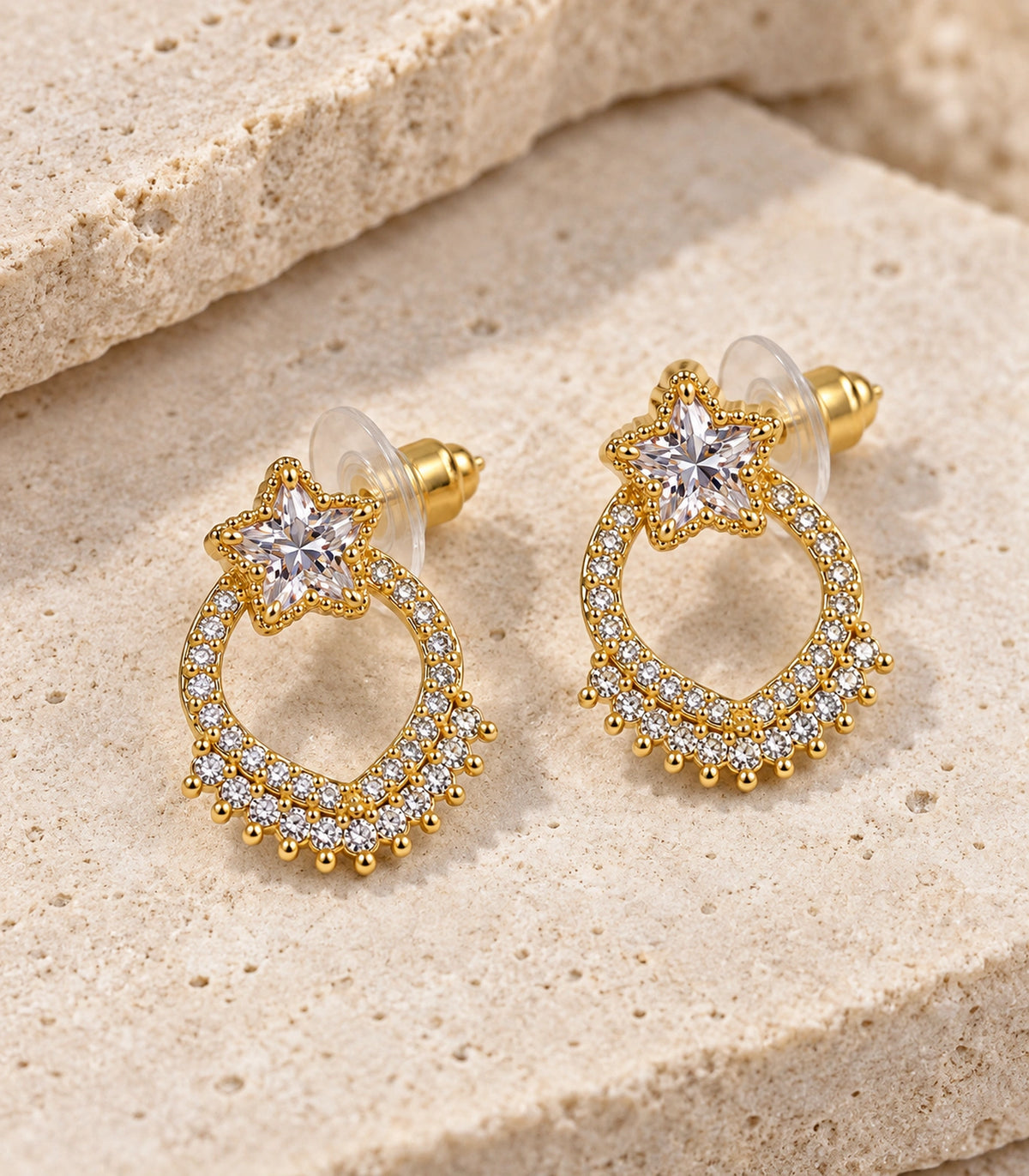 JIMIKI Star Crystal Open Loop Stud Earring Pair in Gold tone, editorial flat lay #color_gold tone